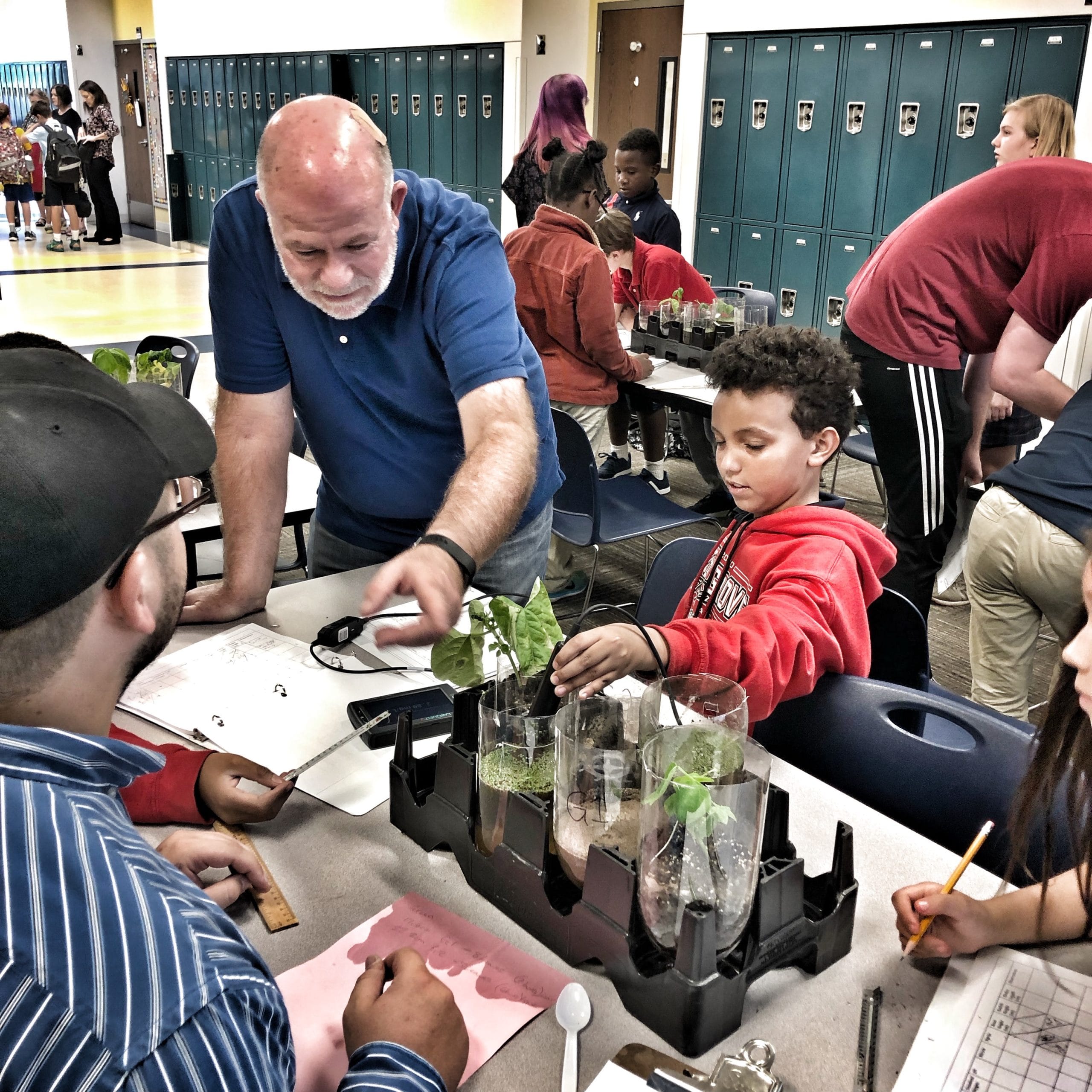 A teacher instructs students about plant health