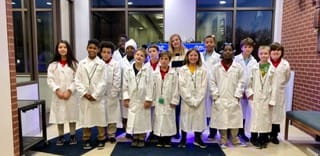 group photo of students wearing lab coats